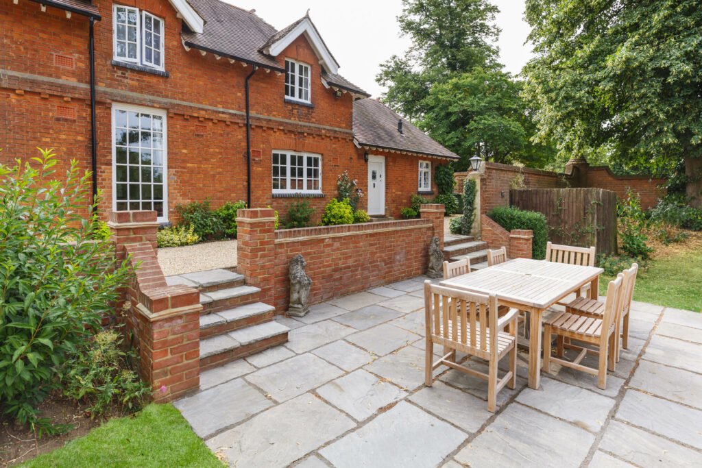 large grey stone brick-patio at the back of house