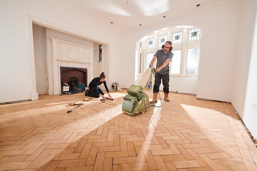 man sanding a parquet floor