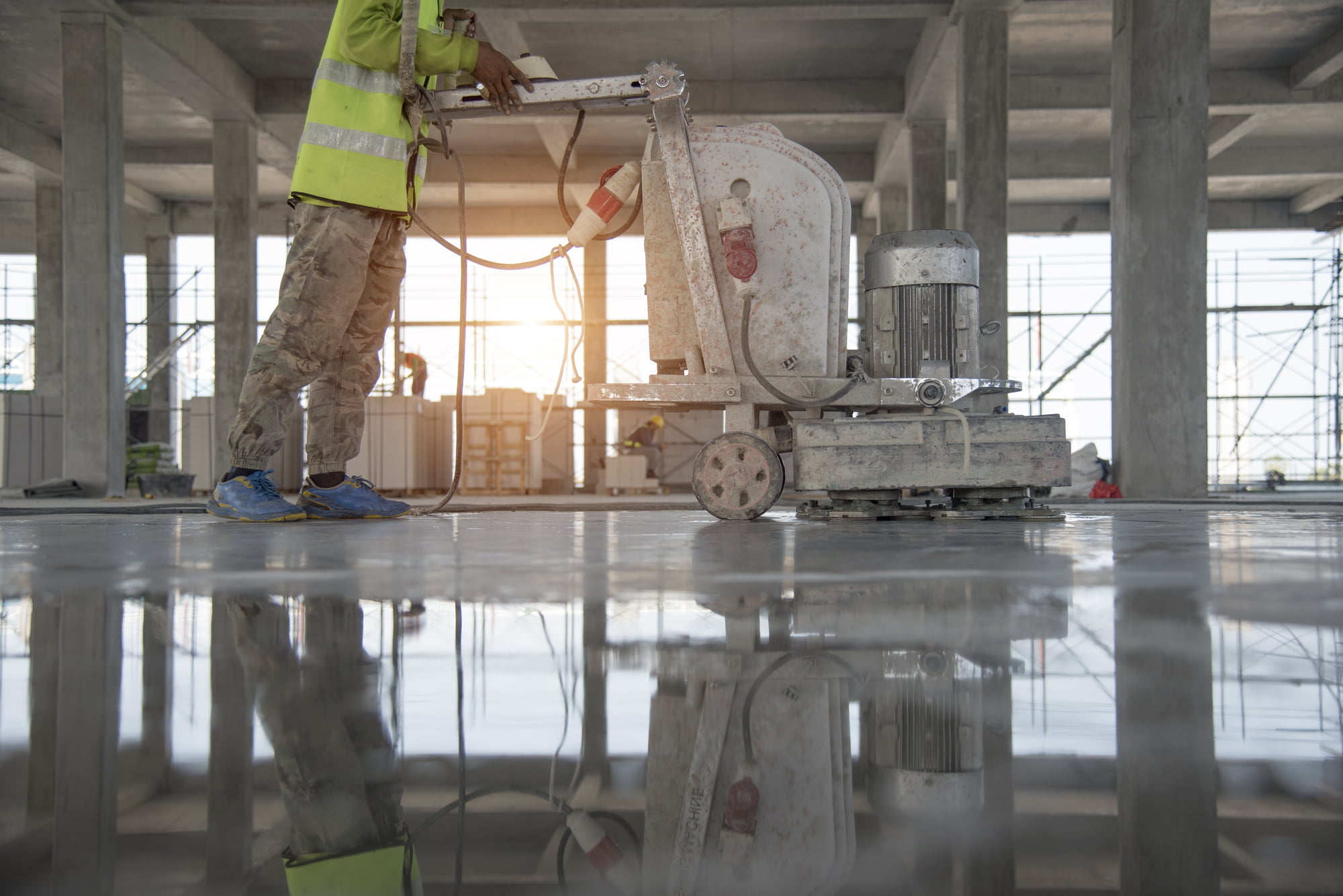 a construction worker is polishing a concrete floor