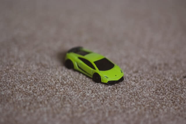 Green Lamborghini toy on a beige carpet