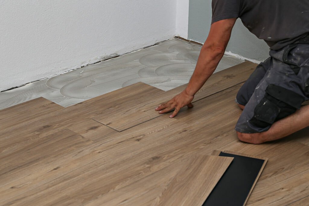 a man installing vinyl floor tiles