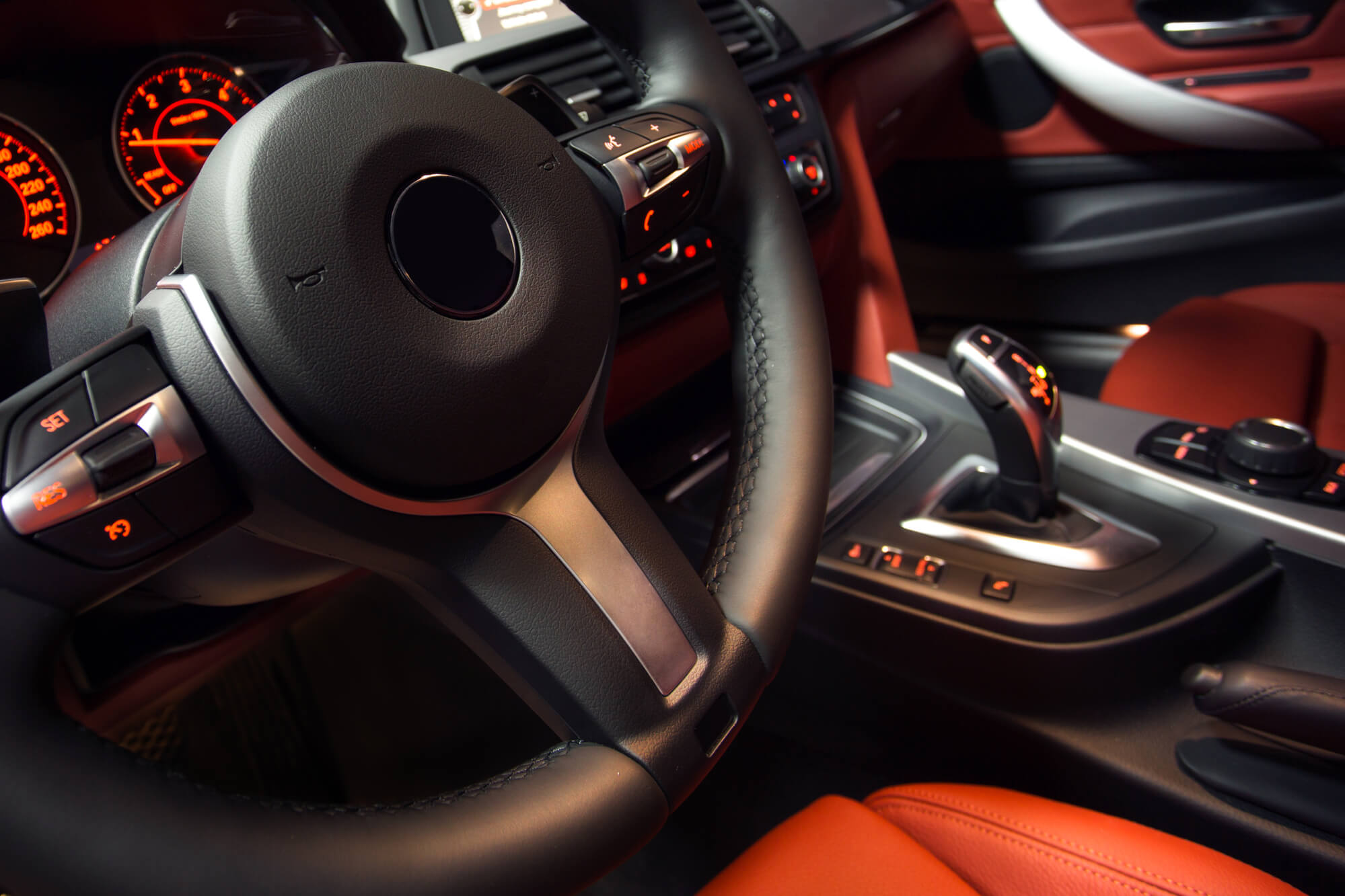 BMW red interior, close up view to steering and gearbox in background