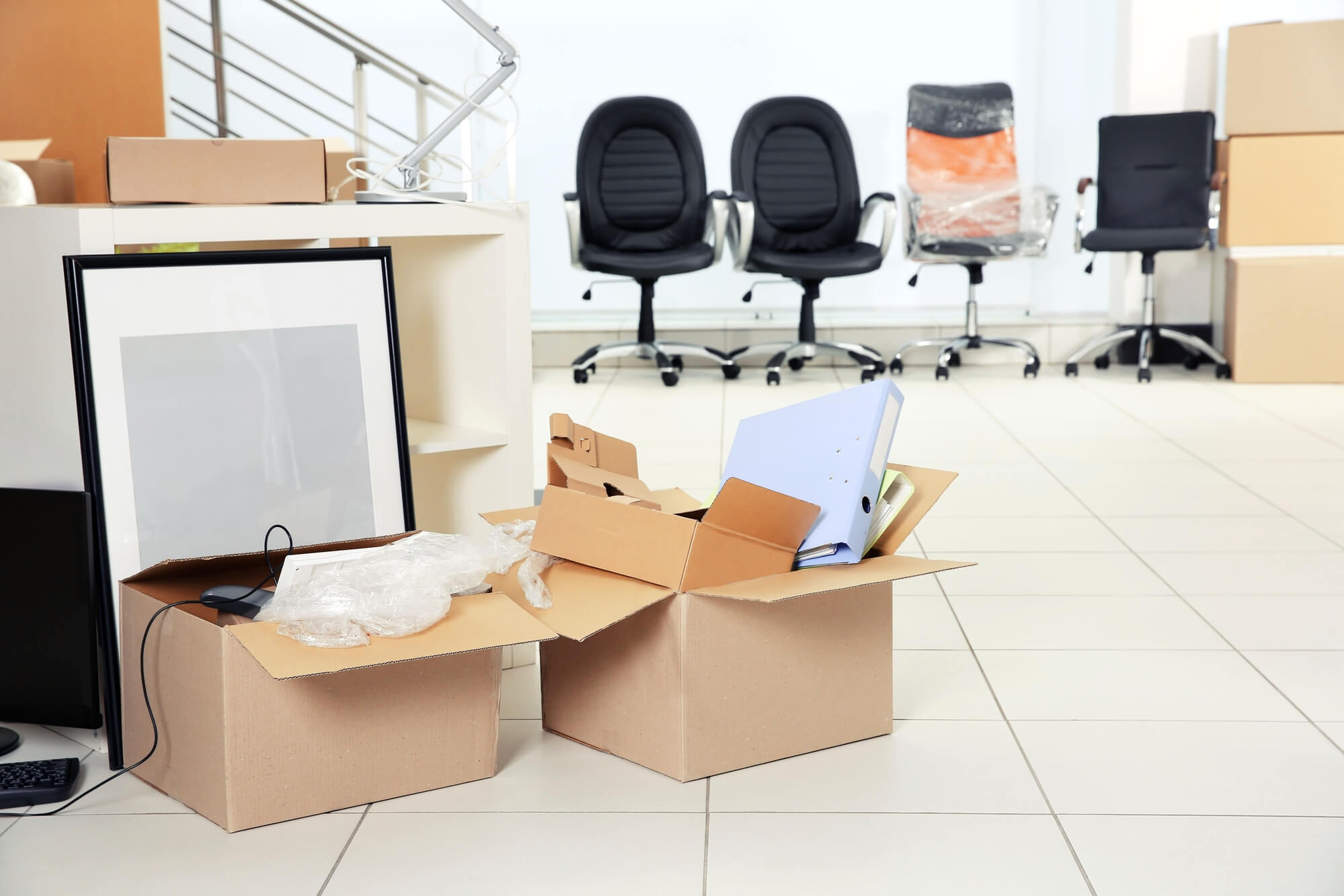 office chairs wrapped in bubble and office supplies packed in a box 